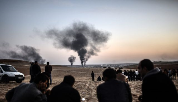 Bildquelle: AFP  Menschen die machtlos zusehen, wie Rauch von der Stadt Kobani, am 26. Oktober 2014 aufsteigt.